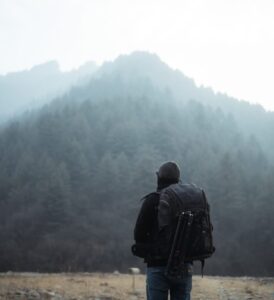 Person with backpack in misty landscape