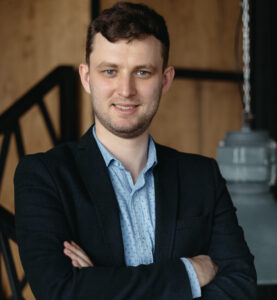 Person in suit holding coffee cup.